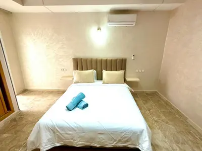 a bedroom with a large white bed with a blue object on it at Appartement centre ville avec Wifi 200 Mo in Fès