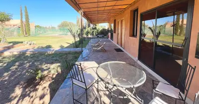 a patio with a table and chairs on a house at Maison d'Hotes Oasis Marrakech Route dOuarzazate in Oulad Akkou