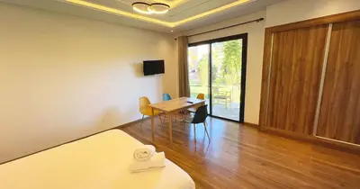 a room with a bed and a desk and a table at Maison d'Hotes Oasis Marrakech Route dOuarzazate in Oulad Akkou