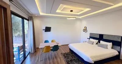 a bedroom with a bed and a table and chairs at Maison d'Hotes Oasis Marrakech Route dOuarzazate in Oulad Akkou