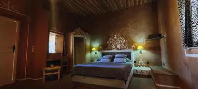 a bedroom with a bed with blue pillows at Auberge Merzane in Merzane