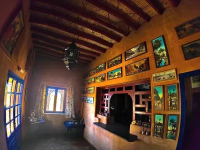 a living room with a wall with paintings on it at Auberge Merzane in Merzane