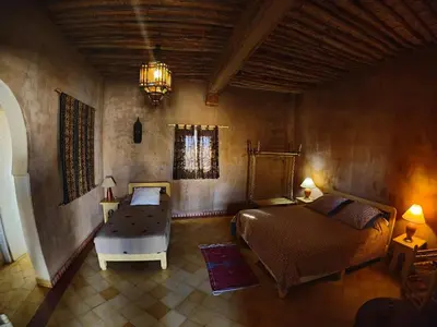 a bedroom with a bed and a chair in a room at Auberge Merzane in Merzane