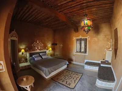 a bedroom with a bed and a chandelier at Auberge Merzane in Merzane