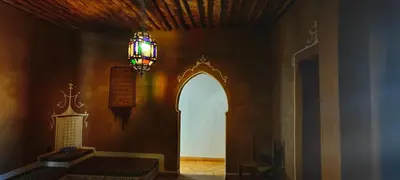 a room with a chandelier and an archway in a wall at Auberge Merzane in Merzane