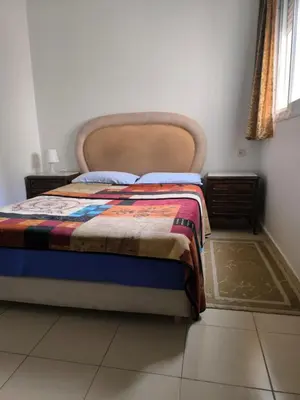 a bedroom with a bed with a blanket on it at Les jardins d'Ifrane in Ifrane