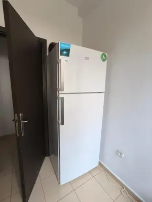 a white refrigerator in a room with a black door at Les jardins d'Ifrane in Ifrane