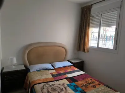 a bedroom with a bed with a quilt and a window at Les jardins d'Ifrane in Ifrane