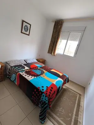 a bedroom with a bed with a colorful comforter at Les jardins d'Ifrane in Ifrane