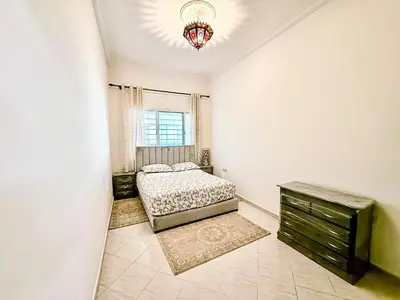 a bedroom with a bed and a window and a dresser at Appartement Prestige Kebibat - Charme marocain in Oulad Akkou