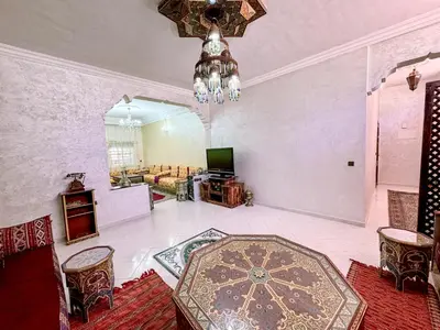 a large living room with a chandelier and a couch at Appartement Prestige Kebibat - Charme marocain in Oulad Akkou