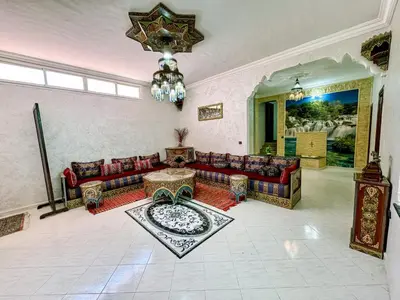 a living room with a couch and a chandelier at Appartement Prestige Kebibat - Charme marocain in Oulad Akkou