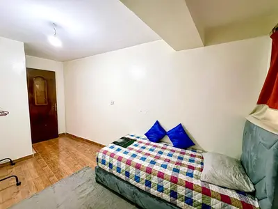 a bedroom with a bed with blue pillows at Appartement Prestige Kebibat - Charme marocain in Oulad Akkou