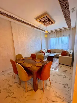 a living room with a table and a couch at Appartement Calme & Moderne in Meknès
