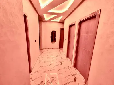 a corridor of a building with a marble floor at Appartement Calme & Moderne in Meknès