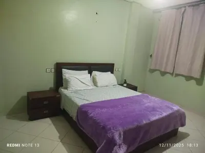a bedroom with a bed with a purple blanket at App luxe riad zitoune in Meknès