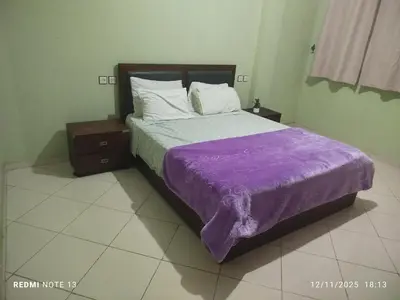 a bed with a purple comforter in a room at App luxe riad zitoune in Meknès