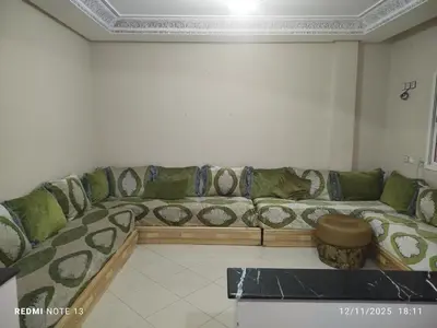 a large couch in a living room with a table at App luxe riad zitoune in Meknès