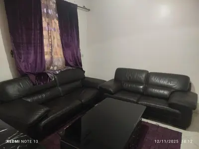 a black leather couch sitting in a living room at App luxe riad zitoune in Meknès
