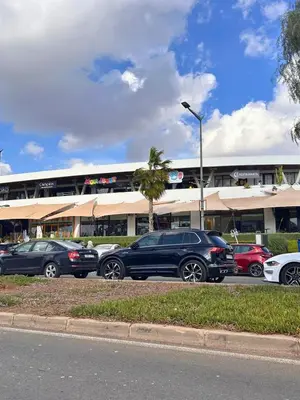 a parking lot with cars parked in front of a building at Elegant cocoon-private pool Bouskoura Green City in Oulad Akkou