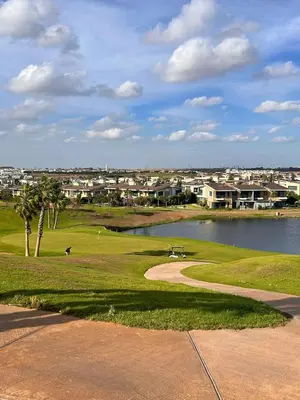 a view of a golf course with a lake and buildings at Elegant cocoon-private pool Bouskoura Green City in Oulad Akkou