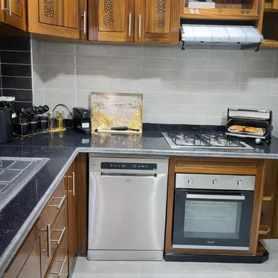 a kitchen with a stove and a white dishwasher at Prime stay downtown Meknes in Meknès