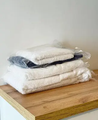 a stack of white towels sitting on a wooden shelf at 2 bedroom apartment in Meknes-Clim, Wifi & Netflix in Meknès