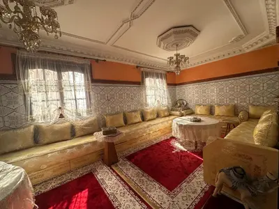 a living room with a long couch and a table at Dar Dyafa in Marrakech 5 minutes from the Airport in Oulad Akkou