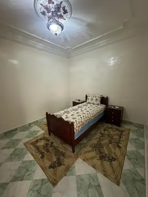 a bedroom with a bed and a chandelier at Dar Dyafa in Marrakech 5 minutes from the Airport in Oulad Akkou
