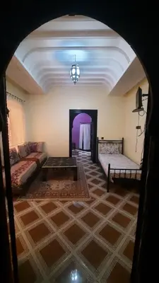a living room with a couch and a table at Riad Des Artistes in Oulad Akkou