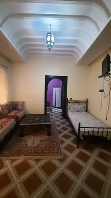 a living room with two beds and a couch at Riad Des Artistes in Oulad Akkou