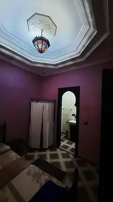 a living room with a ceiling and a chandelier at Riad Des Artistes in Oulad Akkou