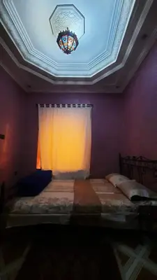 a bedroom with a bed with a window and a ceiling at Riad Des Artistes in Oulad Akkou