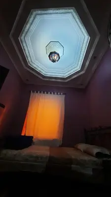 a bedroom with a ceiling with a window and a bed at Riad Des Artistes in Oulad Akkou