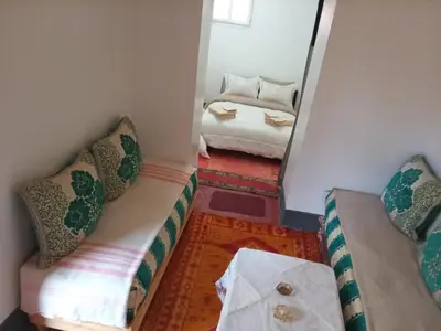 a small room with a couch and a bed at skoura in Oulad el Guern