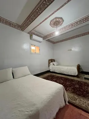 a bedroom with two beds and a ceiling at skoura in Oulad el Guern