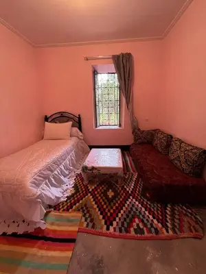 a bedroom with a bed and a window and a rug at skoura in Oulad el Guern
