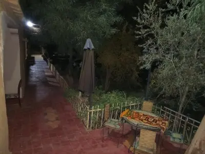 a patio with an umbrella and a table and chairs at skoura in Oulad el Guern