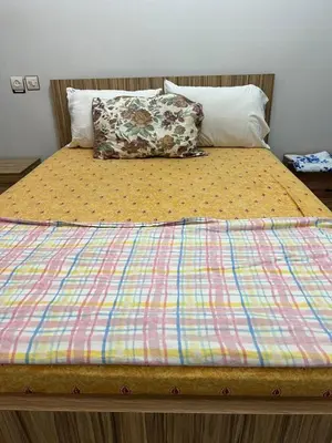 a bed with a colorful comforter and a pillow at OFPPT Otmania in Meknès