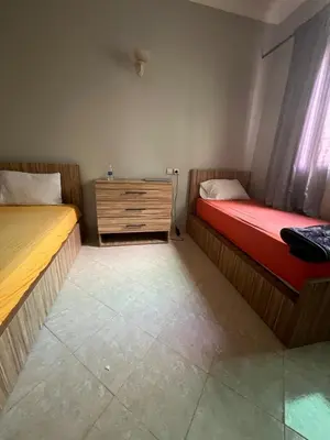 a room with two beds and a dresser in it at OFPPT Otmania in Meknès