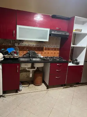 a kitchen with red cabinets and a sink at OFPPT Otmania in Meknès
