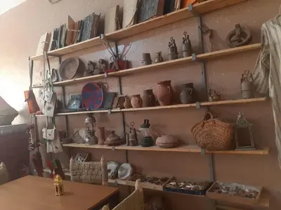 a wall with shelves filled with pots and pans at شمس ميبلادن Tafoukt N' Mibladen in Midelt