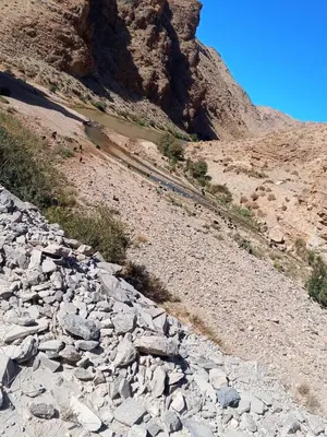 a rocky hillside with a river and a mountain at شمس ميبلادن Tafoukt N' Mibladen in Midelt