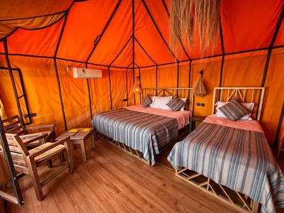 a bedroom with two beds in a tent at Merzouga Infinity Dunes Camp in Merzouga
