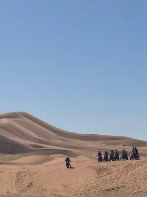 a group of people riding motorcycles in the desert at Merzouga Infinity Dunes Camp in Merzouga