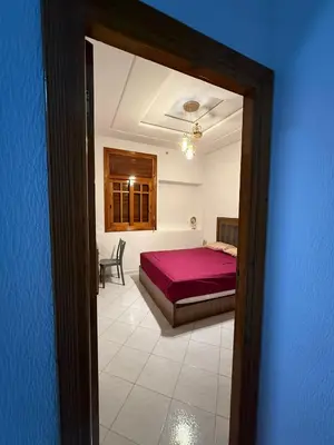 a bedroom with a bed and a chair in a room at appartement in Fès