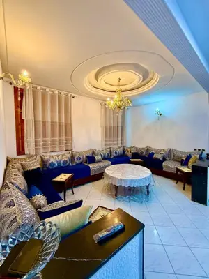 a living room with a couch and a table at appartement in Fès