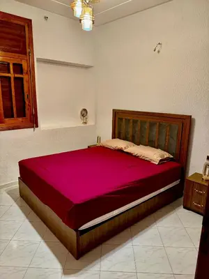 a bedroom with a large bed with a red blanket at appartement in Fès