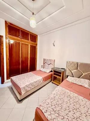 a bedroom with two beds and a chair in it at appartement in Fès
