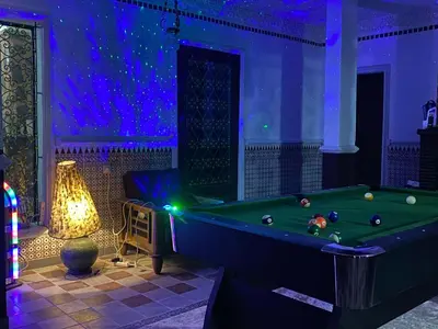 a room with a pool table and a lamp at Suite avec salle de bain privée das un beau Riad avec piscine in Aghmat